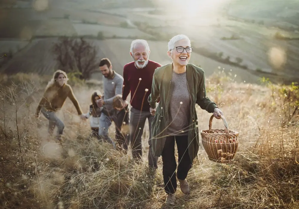 A family walking through a sunny meadow smiling