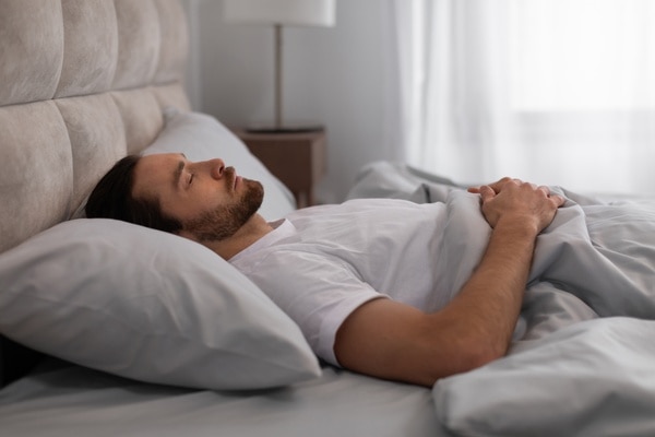  Man sleeping on his back, with pillow