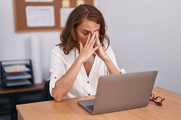  woman touching her face and having difficulty concentrating